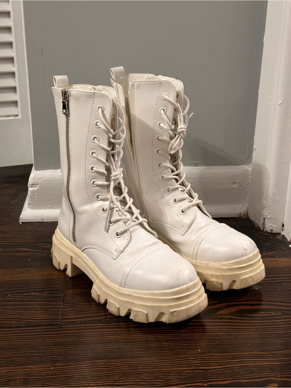 White combat boots with chunky sole and lace up detail